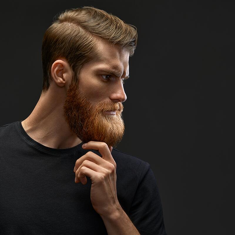 Hansome bearded with hands behind head.